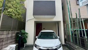 A modern two-story building with a white car parked in front.