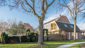 A residential house with a sloped roof, large windows, and a visible chimney. - Holiday home for a family! (Katwijk aan Zee)