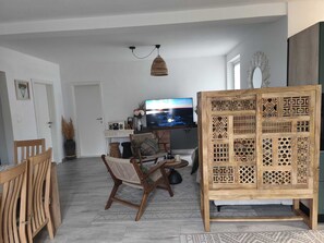 A living room with a TV, wooden furniture, and a decorative screen. - Lux Holiday Home Maribu (Zupa dubrovacka)