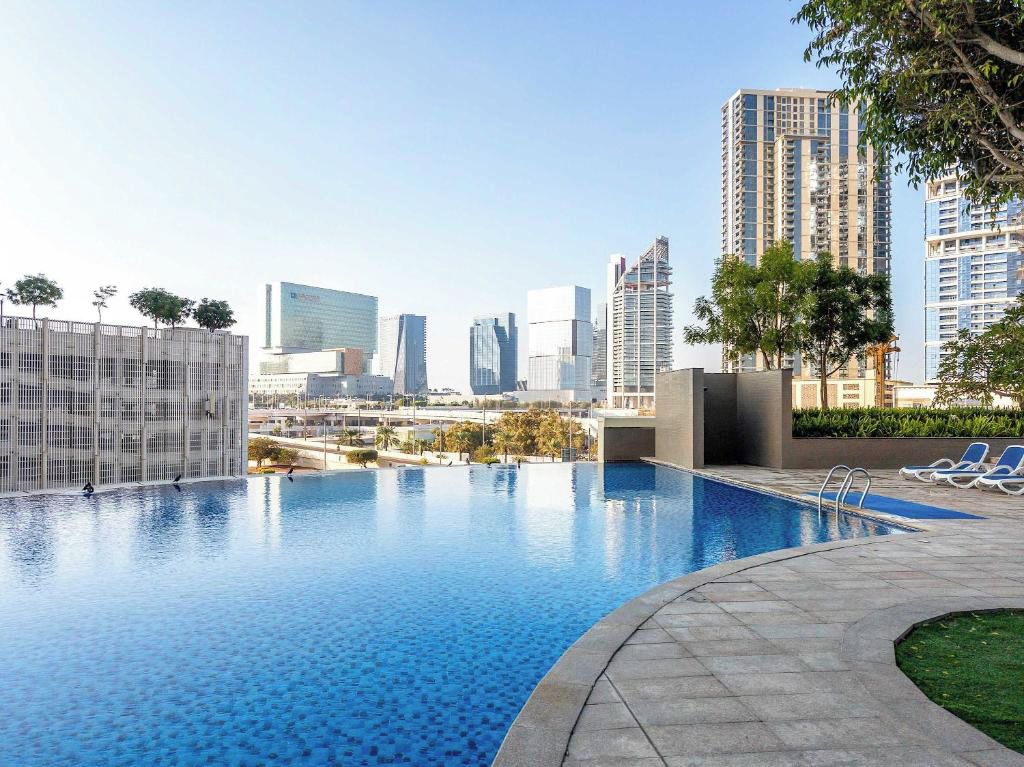 A swimming pool with a cityscape view, surrounded by high-rise buildings.