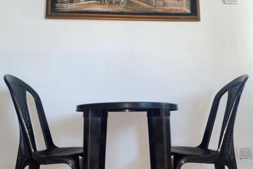 A small round table with two black chairs.