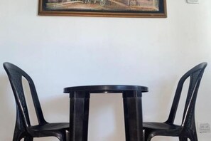 Une petite table ronde avec deux chaises noires.