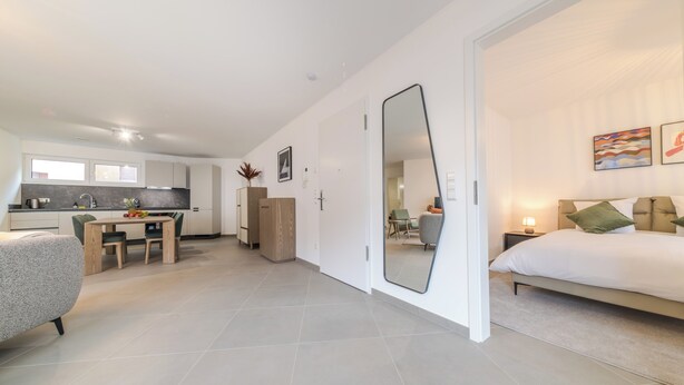 A modern apartment with a kitchen, dining area, and a bedroom. - Halternative Residence Rose (Luxembourg City)