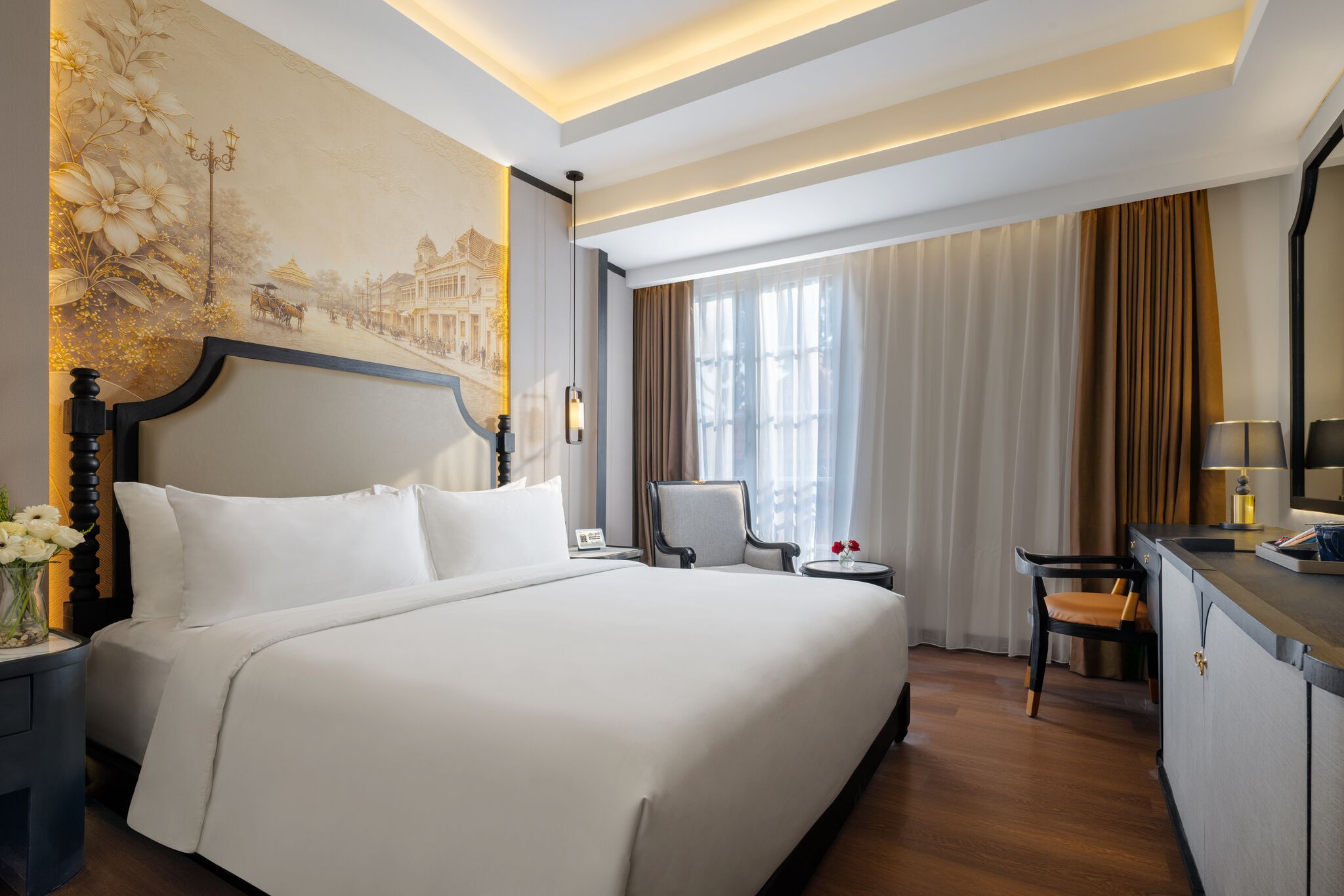 A hotel room with a large bed, a desk, a chair, and a decorative wall mural.