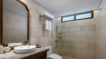 A modern bathroom with a large mirror, a sink, a toilet, and a shower.