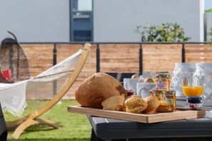 A breakfast setup with bread, pastries, honey, and orange juice on a wooden board. - Harmony Villas Rhodes- Villa Eternity (Ialisos)