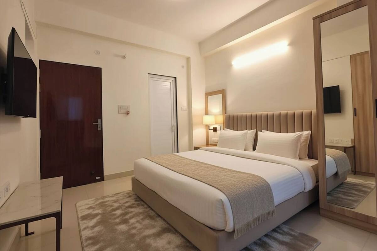 Een moderne hotelkamer met een groot bed, nachtkastjes, een bureau en een televisie.