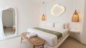 A modern bedroom with a large bed, a bench, a mirror, and two wall-mounted lights. - Suilaya Villa Uluwatu (Pecatu)