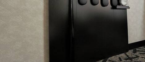 A black wall with a shoe rack holding several pairs of shoes.