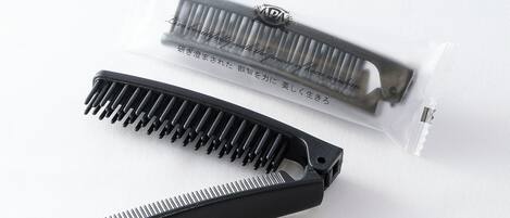 A black comb and a comb case with Japanese text.