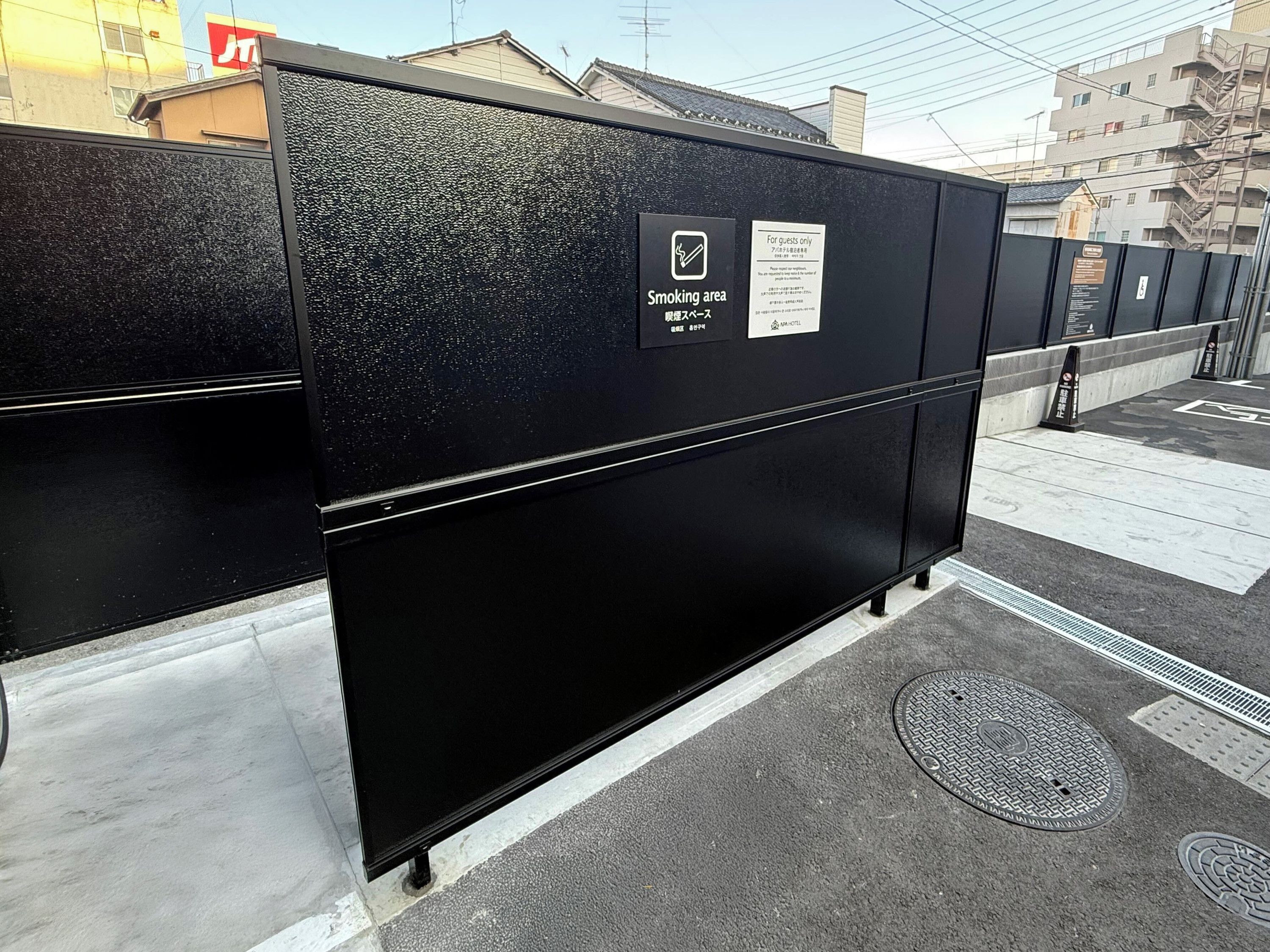 A black metal barrier with a sign indicating a smoking area.
