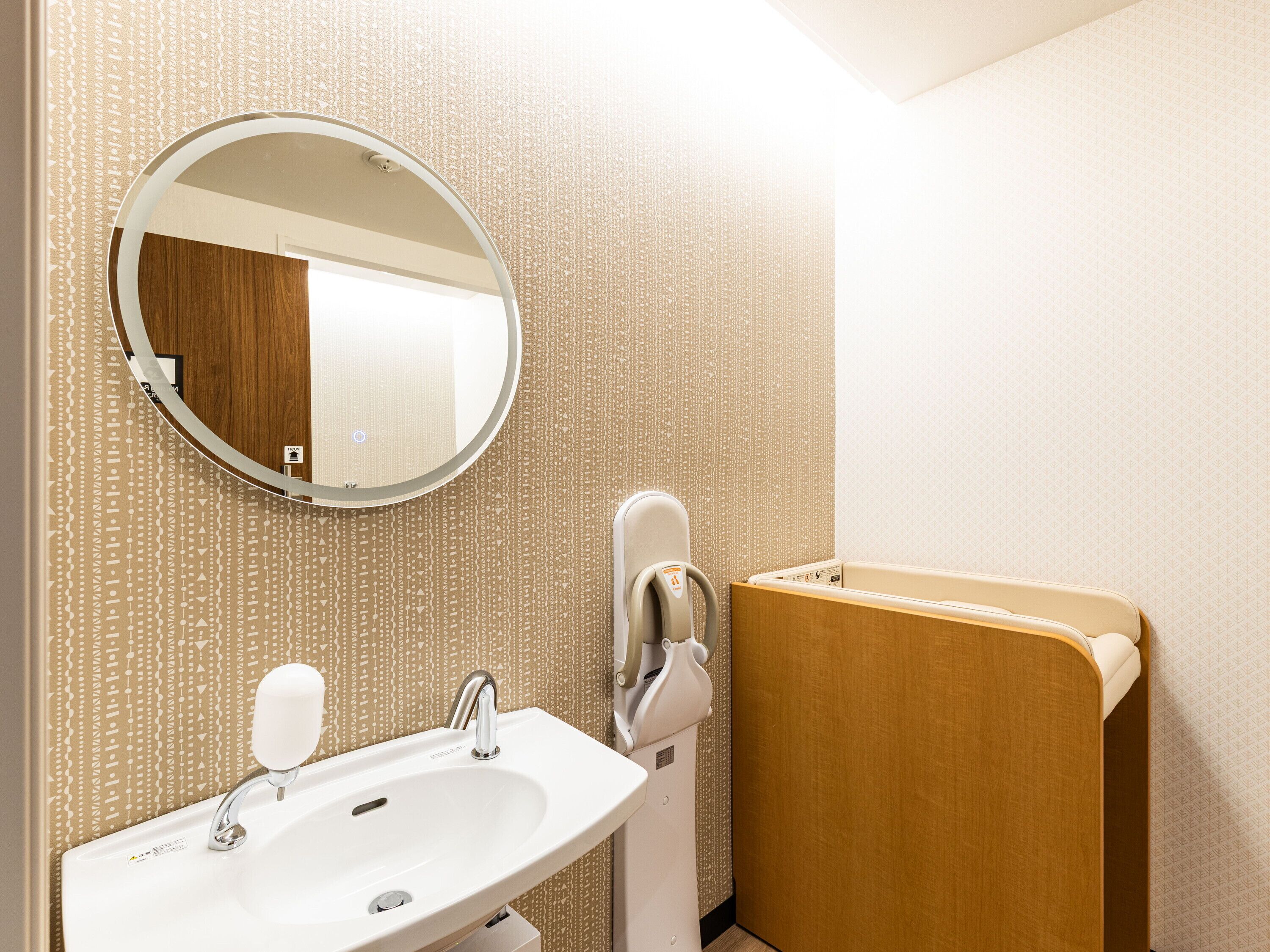 A bathroom with a sink, mirror, and towel rack.