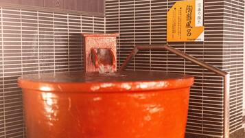Un baño de aguas termales con un banco de madera y una barandilla metálica.