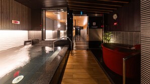 A corridor with a wooden floor, a glass partition, and a red seating area. - APA Hotel Saitama-Shintoshin Ekinishi (Saitama)