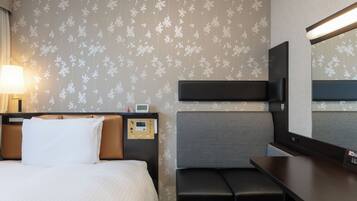 Una habitación de hotel con cama, mesita de noche, lámpara, panel de control, banco y espejo.