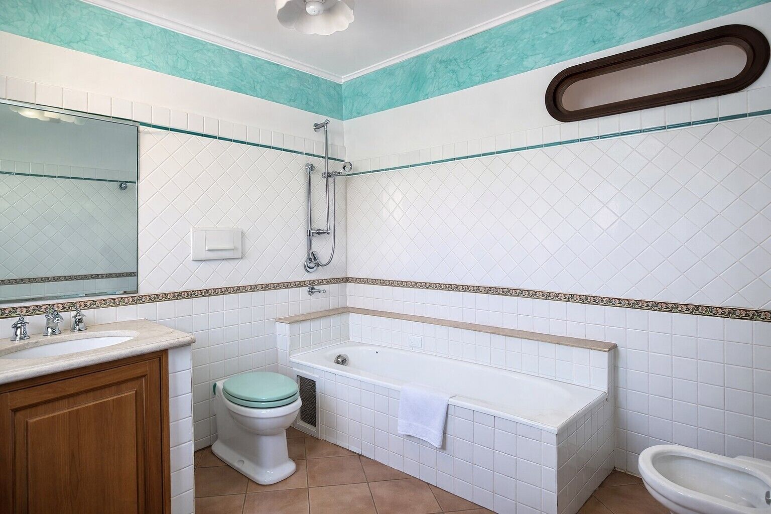 Une salle de bain comprenant des toilettes, un lavabo, une baignoire et une douche.