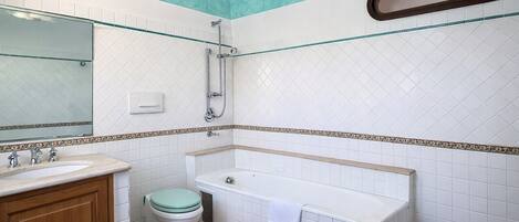 Une salle de bain comprenant des toilettes, un lavabo, une baignoire et une douche.