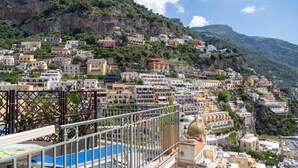 A coastal town with buildings built on a hillside, a prominent dome structure, and a view of the sea. - Hotiday Positano Sea View (Positano)