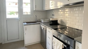 Una cocina moderna con armarios blancos, estufa de acero inoxidable y lavavajillas.