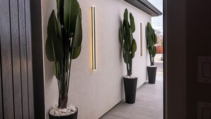A modern building exterior with large potted plants and vertical light fixtures. - The Mustang Collection 49 Newly Built Desert Retreat (Page)
