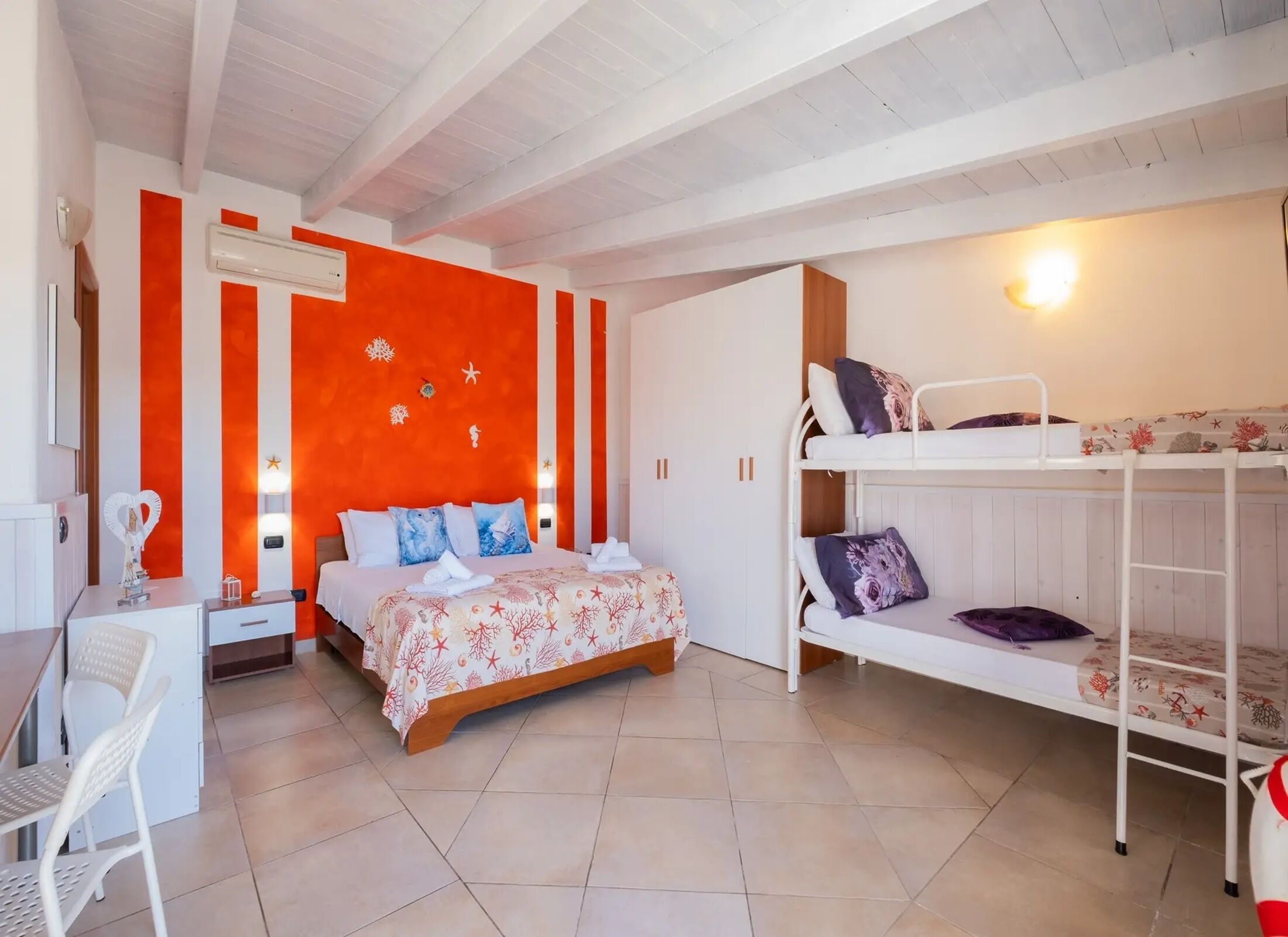 A bedroom with a bed, bunk beds, a desk, and a chair.