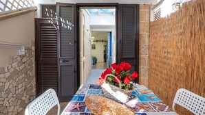 A patio with a table set for two, featuring a starfish centerpiece and a basket of red roses. - Elegant Ground-Floor Apartment in Porto Cesareo – Design moderno Vicino al mare (Porto Cesareo)