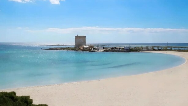 A coastal scene with a sandy beach, a tower-like structure, and a calm sea under a clear sky. - Elegant Ground-Floor Apartment in Porto Cesareo – Design moderno Vicino al mare (Porto Cesareo)