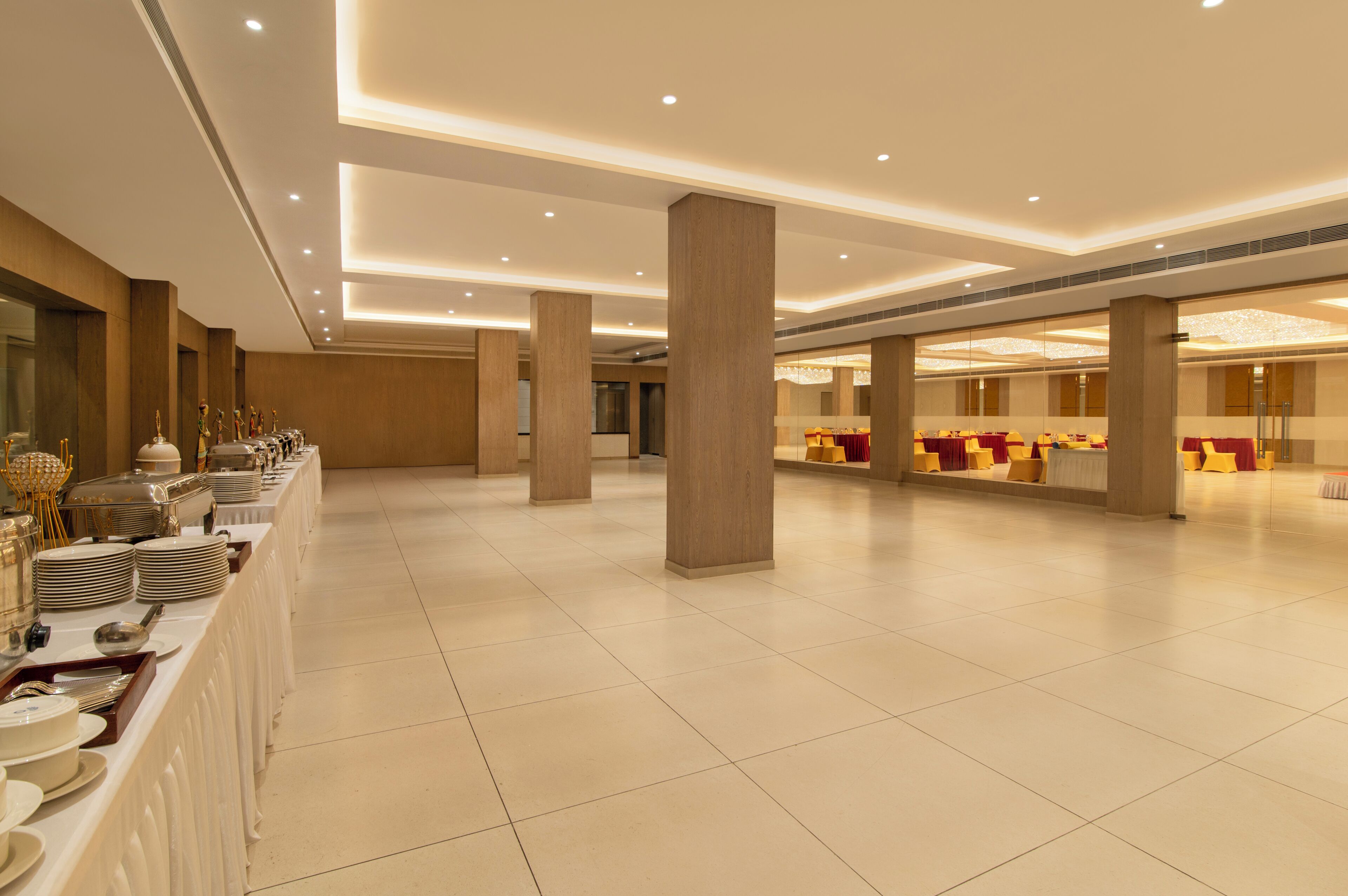 A spacious banquet hall with long tables, high ceilings, and modern lighting.