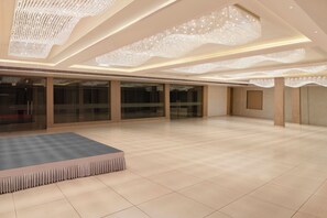 A spacious hotel lobby with a large seating area, glass doors, and a modern chandelier. - Enrise By Sayaji Somnath (Veraval)