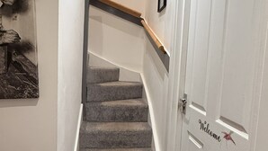 Un escalier recouvert de moquette menant à un palier.
