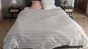 Ein Schlafzimmer mit einem großen Bett, zwei Nachttischen und einem Kopfteil.