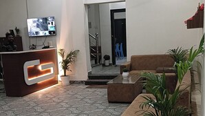 A spacious lobby with a reception desk, seating area, and a tiled floor. - Archana Home Stay-Best Hotel in varanasi (Varanasi)
