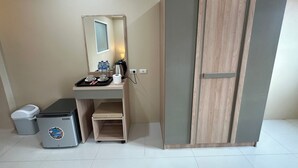 A compact hotel room with a kitchenette, a wardrobe, and a small trash bin. - Lexis Residence - Newly Renovated Rooms (Tambon Patong)