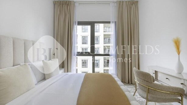 Moderni hotellihuone, jossa on suuri sänky, työpöytä ja tuoli.