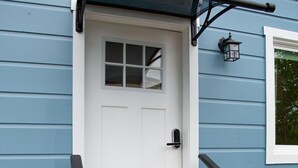 A white door with a small window, a black handrail, and wooden steps leading up to it. - The Marin Modern, 2BR/2BA + Private Garage (San Rafael)