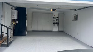 A clean, modern interior with a white floor, a staircase leading to a door, and a small window. - The Marin Modern, 2BR/2BA + Private Garage (San Rafael)