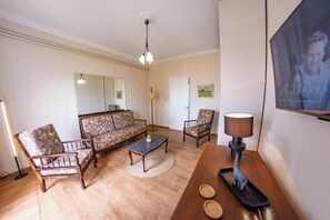 A living room with a sofa, two armchairs, a coffee table, and a lamp. - Corfu City View Loft - a loft with incredibly views in the historical centre (Corfu)