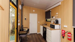 A compact kitchen with a microwave, sink, and coffee maker.