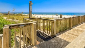A wooden boardwalk leading to a beach with a sign indicating a private beach entrance. - Bluewater 902 (Orange Beach)