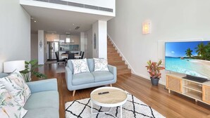 A modern living room with a sofa, coffee table, and TV. - Stylish Apartment Near Mandurah’s Best Spots (Mandurah)