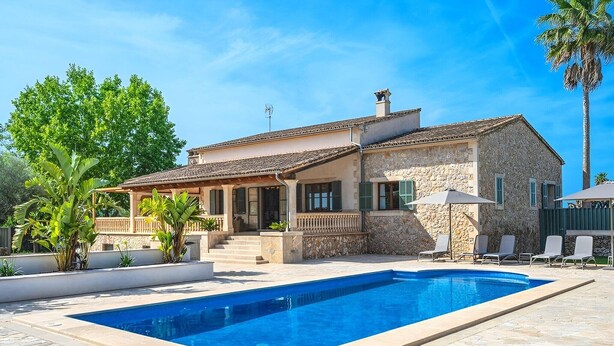 Una casa in pietra con piscina, area relax all'aperto e patio coperto.
