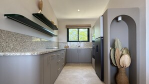 Eine moderne Küche mit Granit-Arbeitsplatten, grauen Schränken und einem eingebauten Ofen.