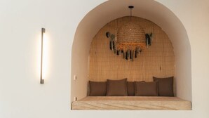 Ein Schlafzimmer mit einem Bett unter einer gewölbten Decke, einer Wandleuchte und einem Wandbild.