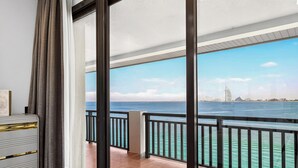 Un balcon avec vue sur la mer et un point de repère situé au loin.