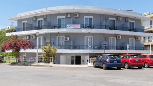 A two-story building with balconies, air conditioning units, and a sign for 'Serenity City Hotel'. - Amethyst Rooms (Rhodes)