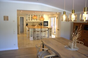 A spacious kitchen with white cabinets, a central island, and pendant lighting. - Hygge vacation home Mayland in an idyllic location | Arrive & take a deep breath (Humptrup)