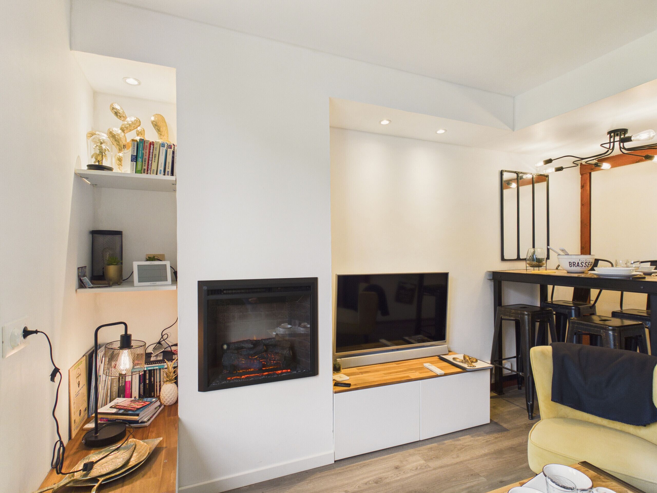 A modern living room with a fireplace, a dining area, and a sofa.