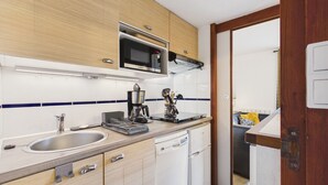 A compact kitchen with a microwave, coffee maker, and dishwasher. - Shared pool, beach 300m, accommodation for 2 (Arzon)