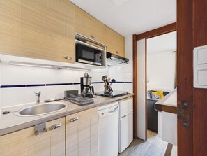 A compact kitchen with a microwave, coffee maker, and dishwasher. - Shared pool, beach 300m, accommodation for 2 (Arzon)