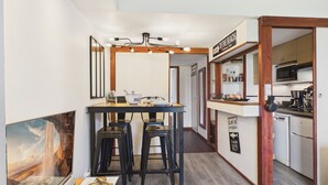 A compact kitchen with a dining area, wooden accents, and a view of the beach. - Shared pool, beach 300m, accommodation for 2 (Arzon)